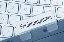 eine Tastatur mit einem Papier mit der Aufschrift Förderprogramm
