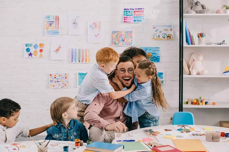 eine Frau und zwei Kinder sitzen an einem Tisch mit einem Buch