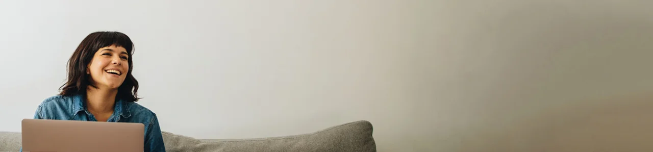 eine Frau sitzt auf einer Couch mit einem Laptop