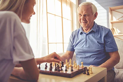 ein Mann und eine Frau spielen Schach in einem Wohnzimmer