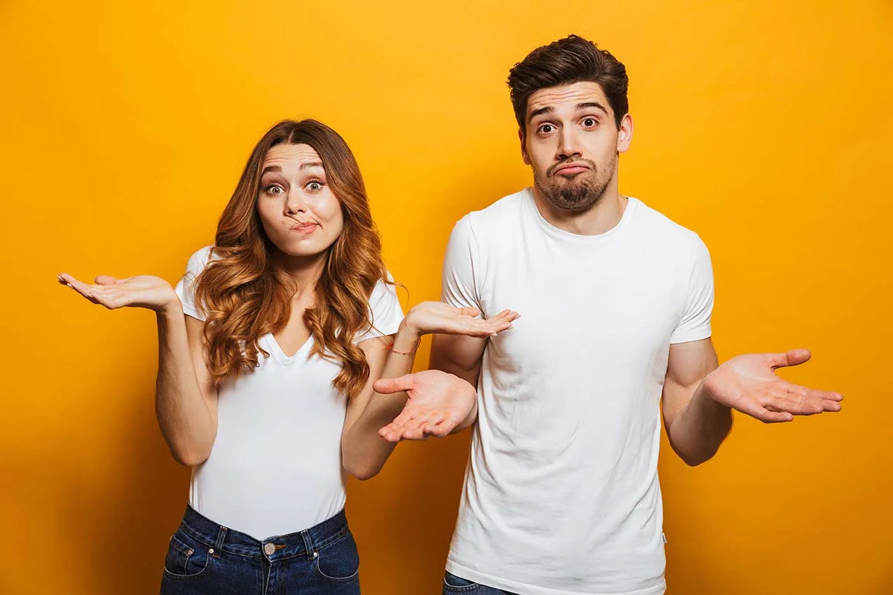 ein Mann und eine Frau stehen vor einer gelben Wand