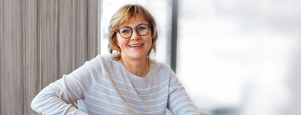 eine Frau sitzt an einem Schreibtisch mit ihrem Laptop