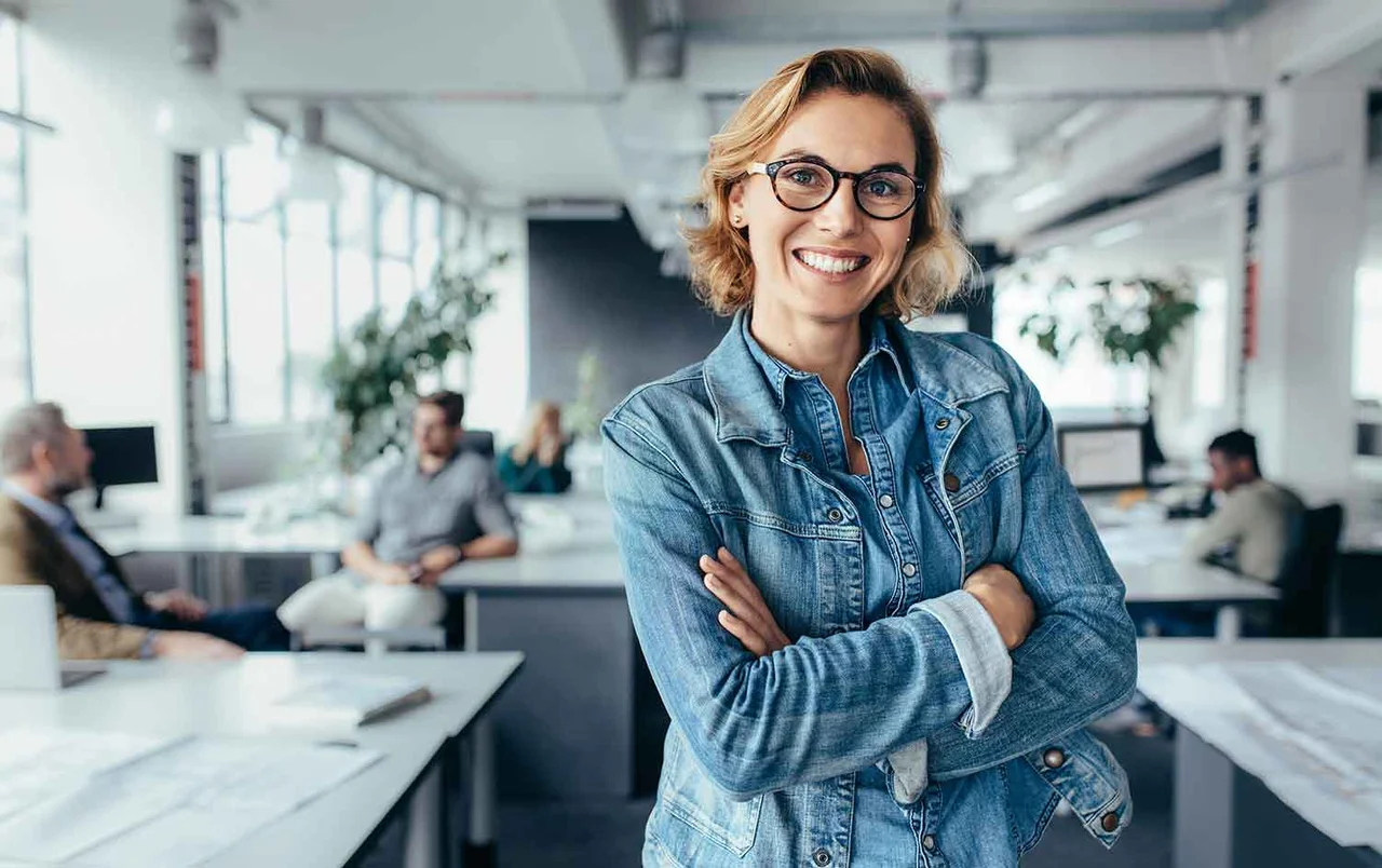 eine Frau in einem Büro mit gekreuzten Armen